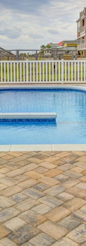Relaxing poolside patio with sun loungers and villas, perfect for a summer retreat.