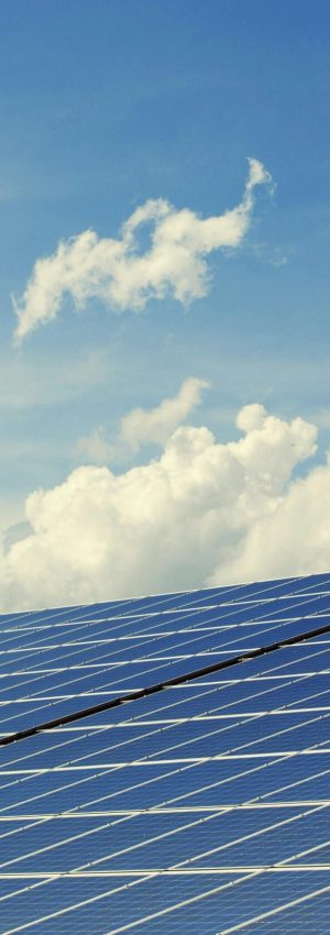 Sleek modern solar panels under a vibrant blue sky with clouds, symbolizing clean energy.